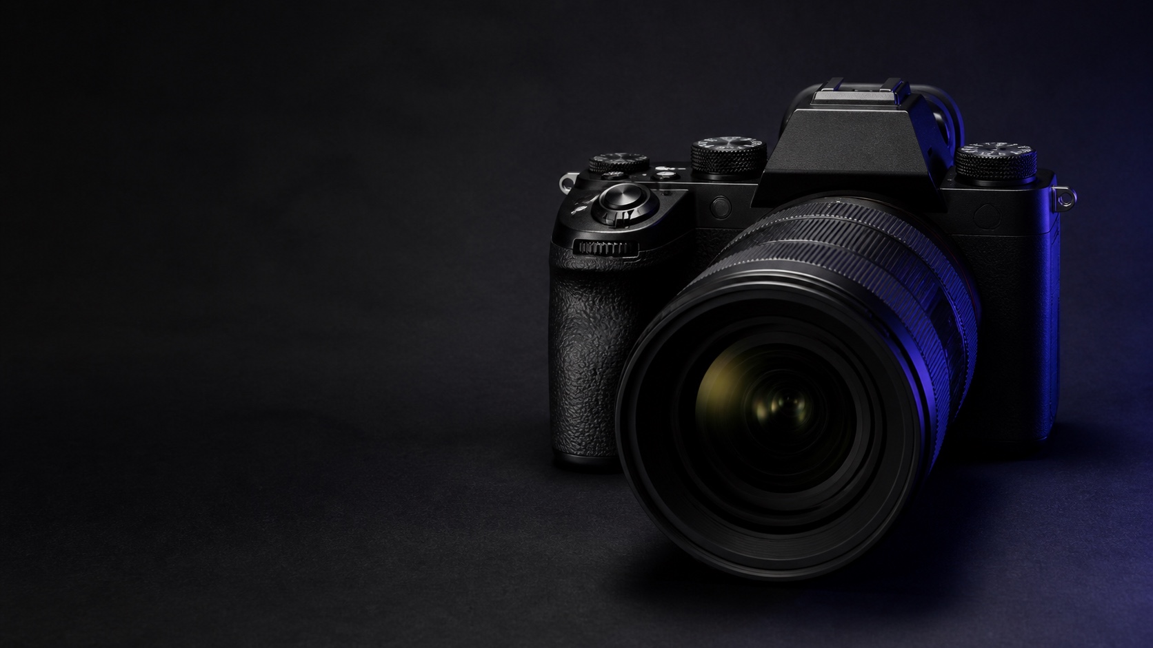 Фотореалистичная предметная иллюстрация флагманской Sony Alpha 1 II с объективом в тёмной графитовой студии с синим акцентом. Иллюстрация для страницы «Продать Sony Alpha 1 II в Москве дорого сегодня».