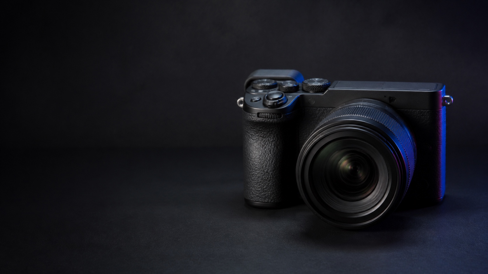 Фотореалистичная предметная иллюстрация компактной Sony Alpha 7C II с offset-видоискателем в тёмной графитовой студии с синим акцентом. Иллюстрация для страницы «Продать Sony Alpha 7C II в Москве дорого сегодня».